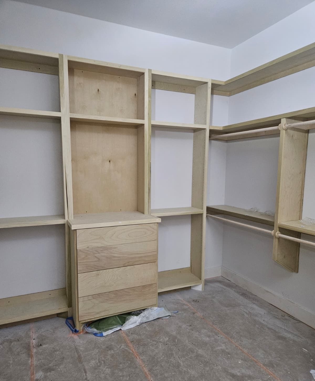 Walk-in closet with a four-drawer dresser tower, shelving and double hanging rods