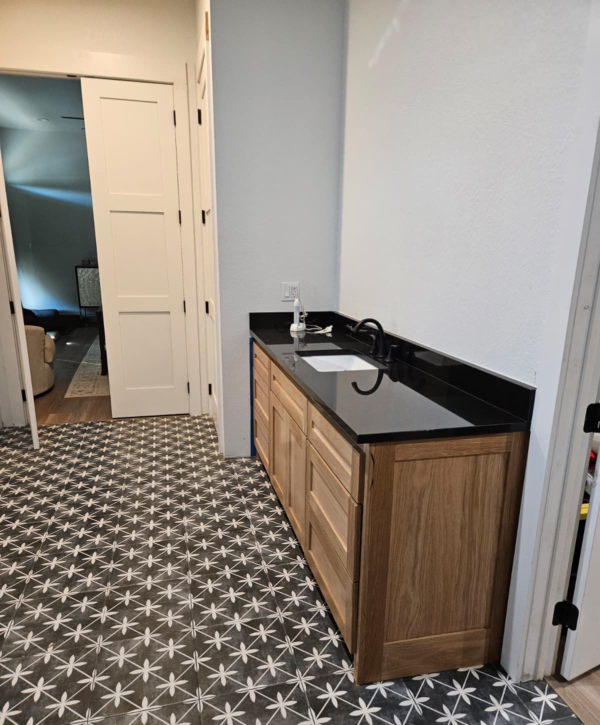 Oak sink cabinet beside a white three-panel shaker door