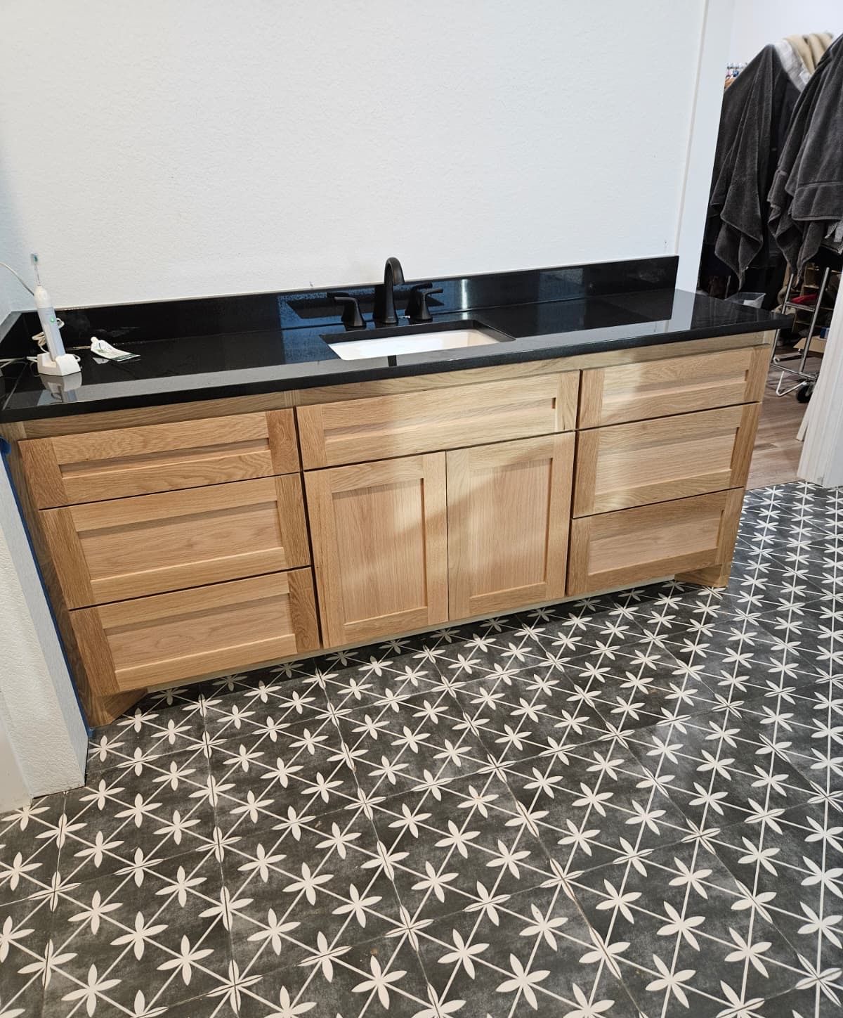 Oak shaker sink cabinet with drawer banks, double doors and a black quartz top